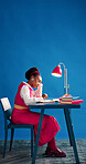Notebook, reading and space with designer black woman in studio for agenda, calendar or schedule. Diary, journal and planner with African employee on blue background for small business planning