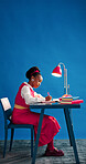 Notebook, space and writing with designer black woman in studio for agenda, calendar or schedule. Diary, journal and notes with African employee on blue background for small business planning