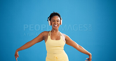 Buy stock photo Black woman, fitness and dancing with headphones in studio, streaming or mockup space on blue background. Girl, happy and portrait with subscription, rhythm and listen to music for exercise in Kenya