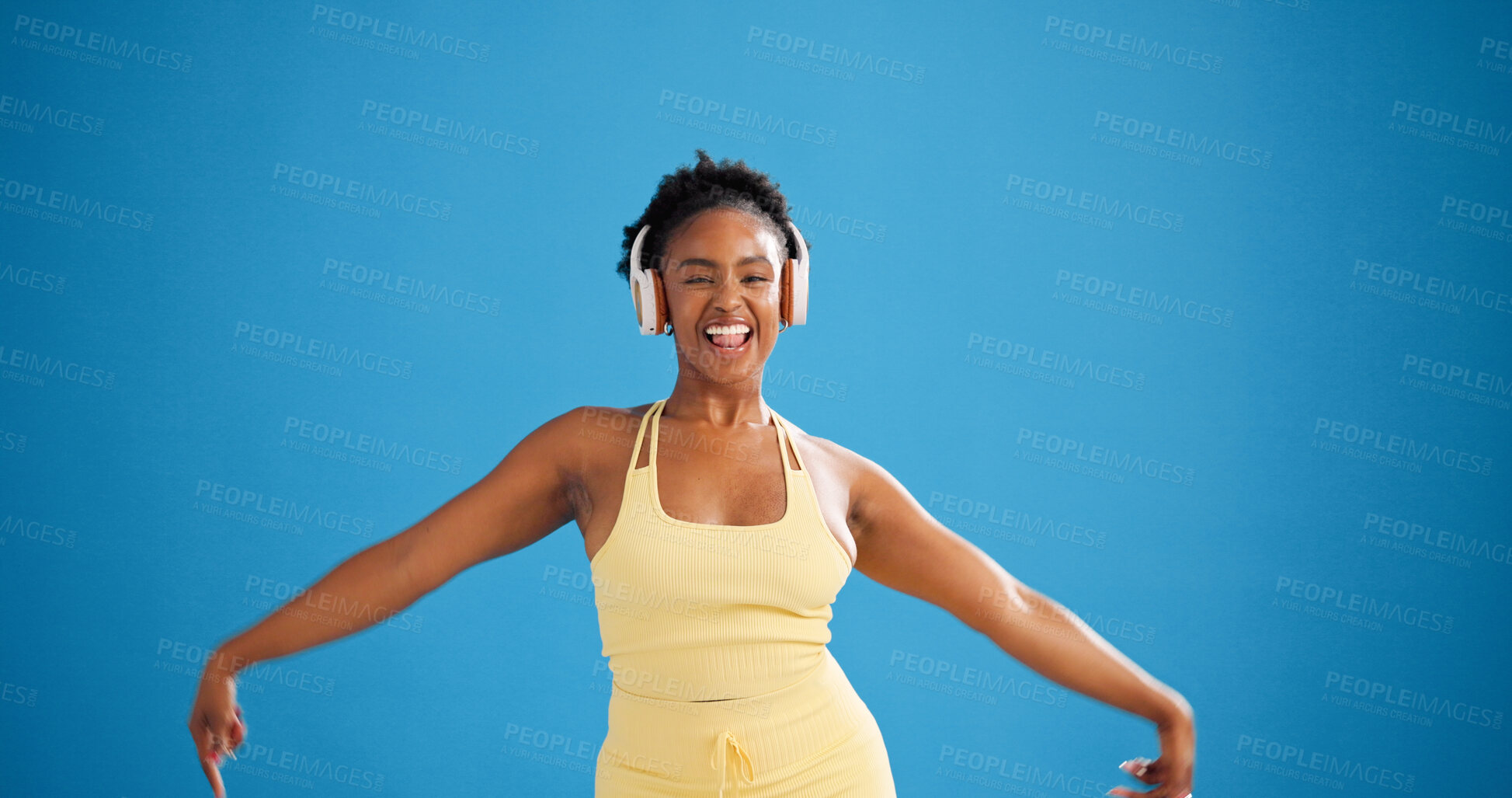Buy stock photo Black woman, fitness and dancing with headphones in studio, streaming or mockup space on blue background. Girl, happy and portrait with subscription, rhythm and listen to music for exercise in Kenya