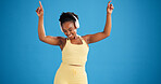 Happy woman, exercise and dance with headphones in studio, streaming or mockup space on blue background. African girl, smile and dancer with audio subscription, rhythm and listen to music for fitness