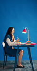 Laptop, notebook and space with designer woman at desk in studio for agenda, calendar or schedule. Computer, journal and thinking with employee person on blue background for small business planning