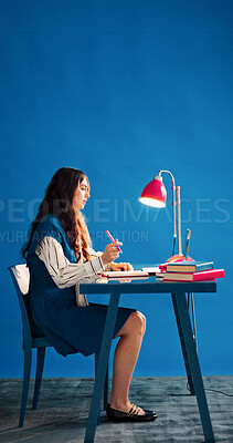 Buy stock photo Laptop, notebook and space with designer woman at desk in studio for agenda, calendar or schedule. Computer, journal and thinking with employee person on blue background for small business planning