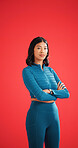Serious, athlete and woman with arms crossed in studio, portrait and pride for fitness with workout. Red background, wellness and person with confidence on space, strong and body care in Colombia