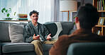 Talking, sofa and man with psychologist in office for advice, help or life coaching session. Mental health, consulting and therapist with male patient for emotional support, wellness or conversation.