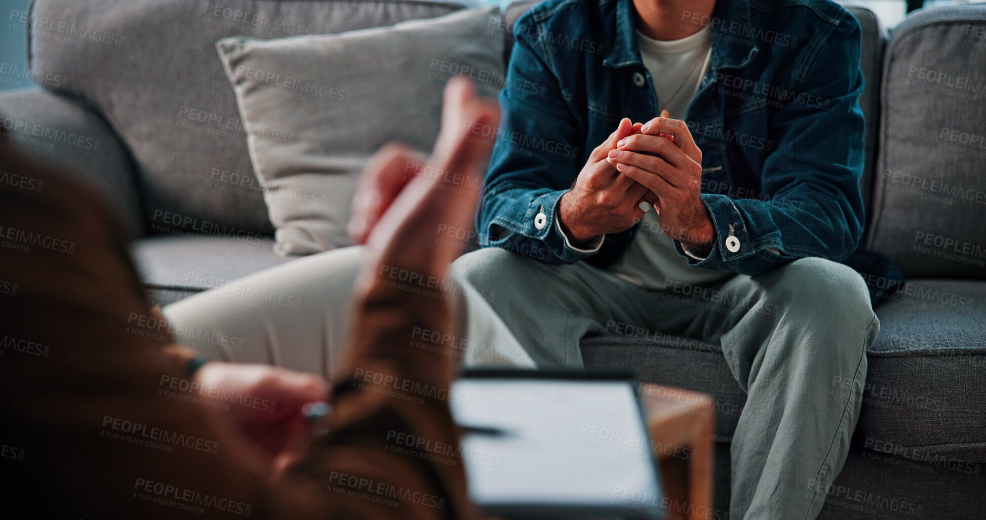 Buy stock photo Hands, anxiety and man on sofa by therapist for emotional support, help or advice on mental health. Nervous, notes and person with life coach for therapy, wellness or counseling session at clinic.
