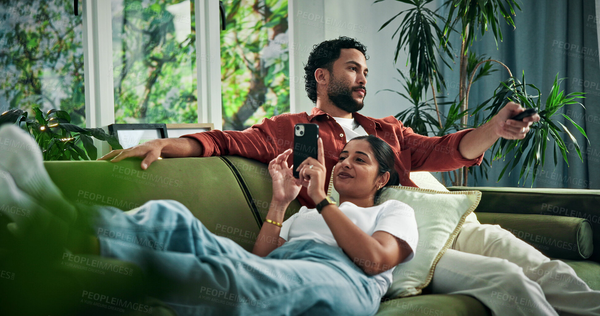 Buy stock photo Happy couple, relax and watching tv with phone on sofa for entertainment together in home. Man, woman and online subscription with mobile smartphone or remote on couch for app, movie or news in house