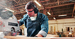 Carpentry, eyewear and sawing machine with man in warehouse for manufacturing or production process. Bandsaw, earmuffs and ppe with person in woodworking plant to resize lumber or timber for project