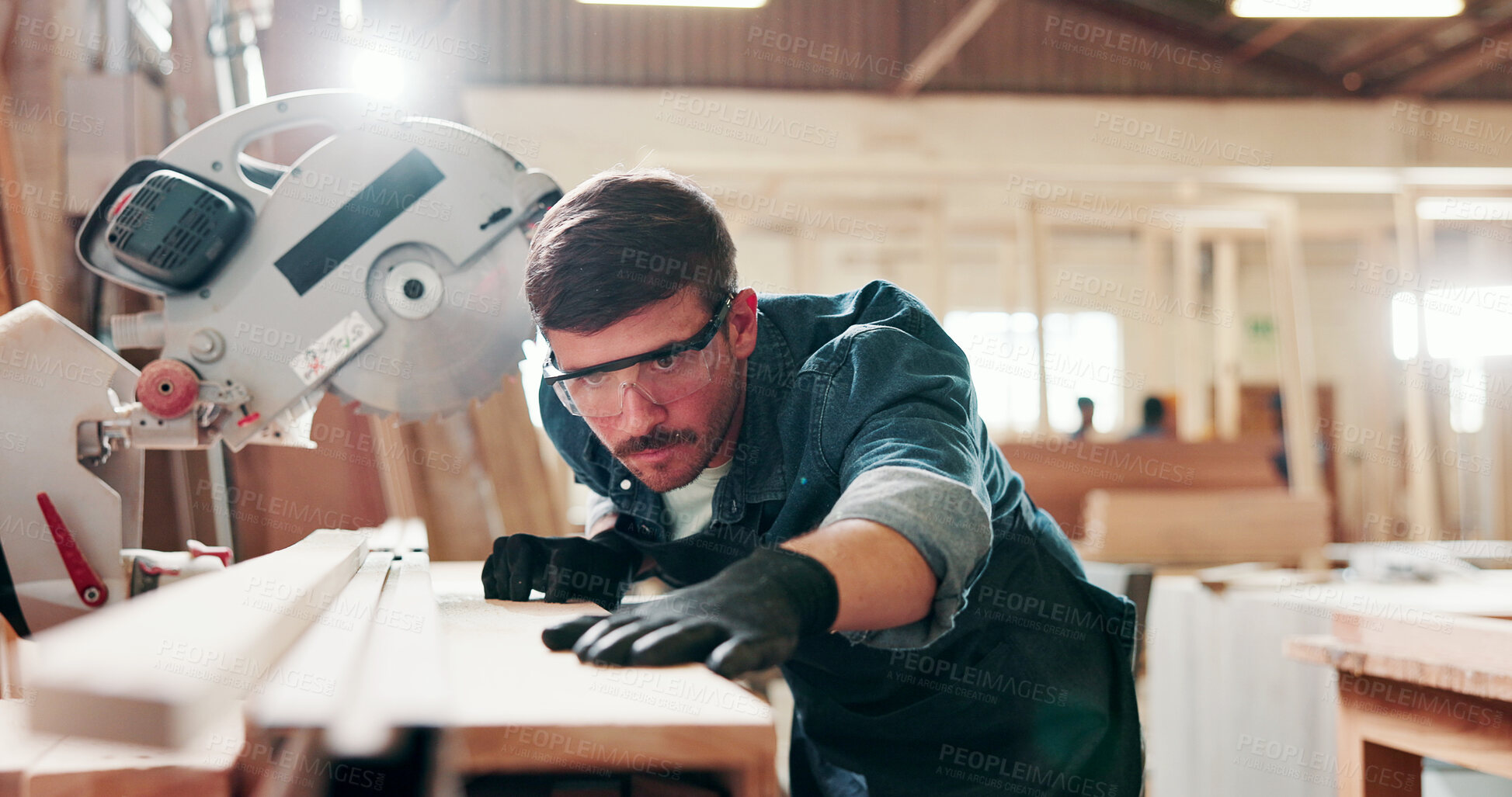 Buy stock photo Man, carpenter and miter saw for wood at workshop with manufacturing process at industrial plant. Person, power tools and technician with equipment for cutting, material and safety goggles at factory