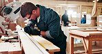 Carpentry, writing and man with tape measure in workshop, construction process and planning for precision. Tools, woodwork and carpenter with plank for creative project, material preparation or craft