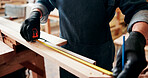 Measuring tape, woodworker and man in workshop for project, planning and manufacture furniture. Industry, craft and male carpenter with equipment on timber material for small business in factory.