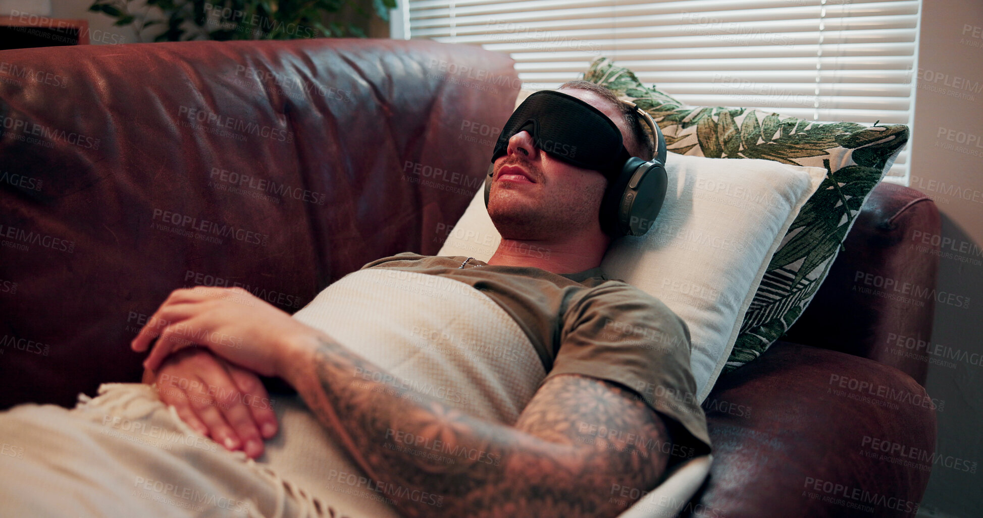 Buy stock photo Headphones, psychology and man with blindfold on couch, sensory deprivation and anxiety counseling. Relaxation therapy, calm and person with mindfulness training for ptsd, therapeutic audio and tech