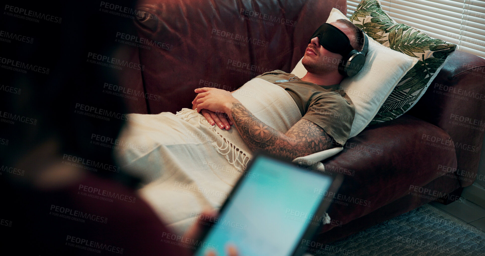 Buy stock photo Therapist, man or headphones with mask in counseling for PTSD healing, bilateral stimulation or help. Audio, patient and blindfold in psychotherapy for trauma evaluation, tablet notes or EMDR on sofa