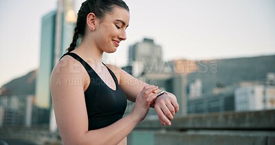 Buy stock photo Fitness, smile and time with woman in city for progress, training or workout tracking as runner. Buildings, exercise and watch with happy athlete outdoor in urban town for health or wellness activity