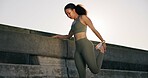 Stretching, sports and woman on bridge in city for running, workout or training for wellness. Athlete, fitness and female person with leg warm up for cardio exercise, health or active in urban town.