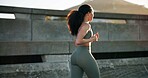 Back, fitness and running with woman on bridge in city for cardio, training or workout routine. Exercise, health and sports with athlete or runner outdoor on street for action, speed and wellness