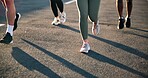 People, legs and running on road for exercise, outdoor fitness or cardio training on asphalt. Feet, athlete group or runner club for sprint, race or practice on street for endurance or weight loss