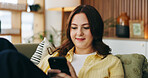 Smile, woman and relax with phone at house for social media, browsing website and chatting. Happy, female person and reading with mobile app for text message, communication and online notification