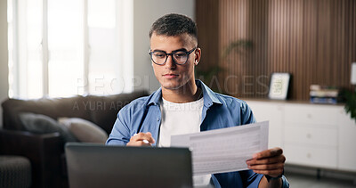 Buy stock photo Documents, laptop and remote work with man in home office for planning, research or review. Computer, paperwork and reading with freelance employee at desk in apartment for small business startup