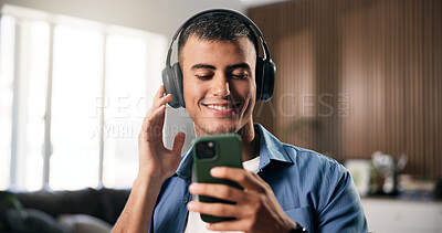 Buy stock photo Man, headphones and happy with phone in home for audio, streaming service and relax in living room. Person, smartphone and listen to music with smile, subscription and scroll for song at apartment
