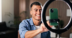 Man, influencer and phone with ring light in home for content creation, happy and recording video. Person, smartphone and smile for live streaming, mobile app and social media post at apartment