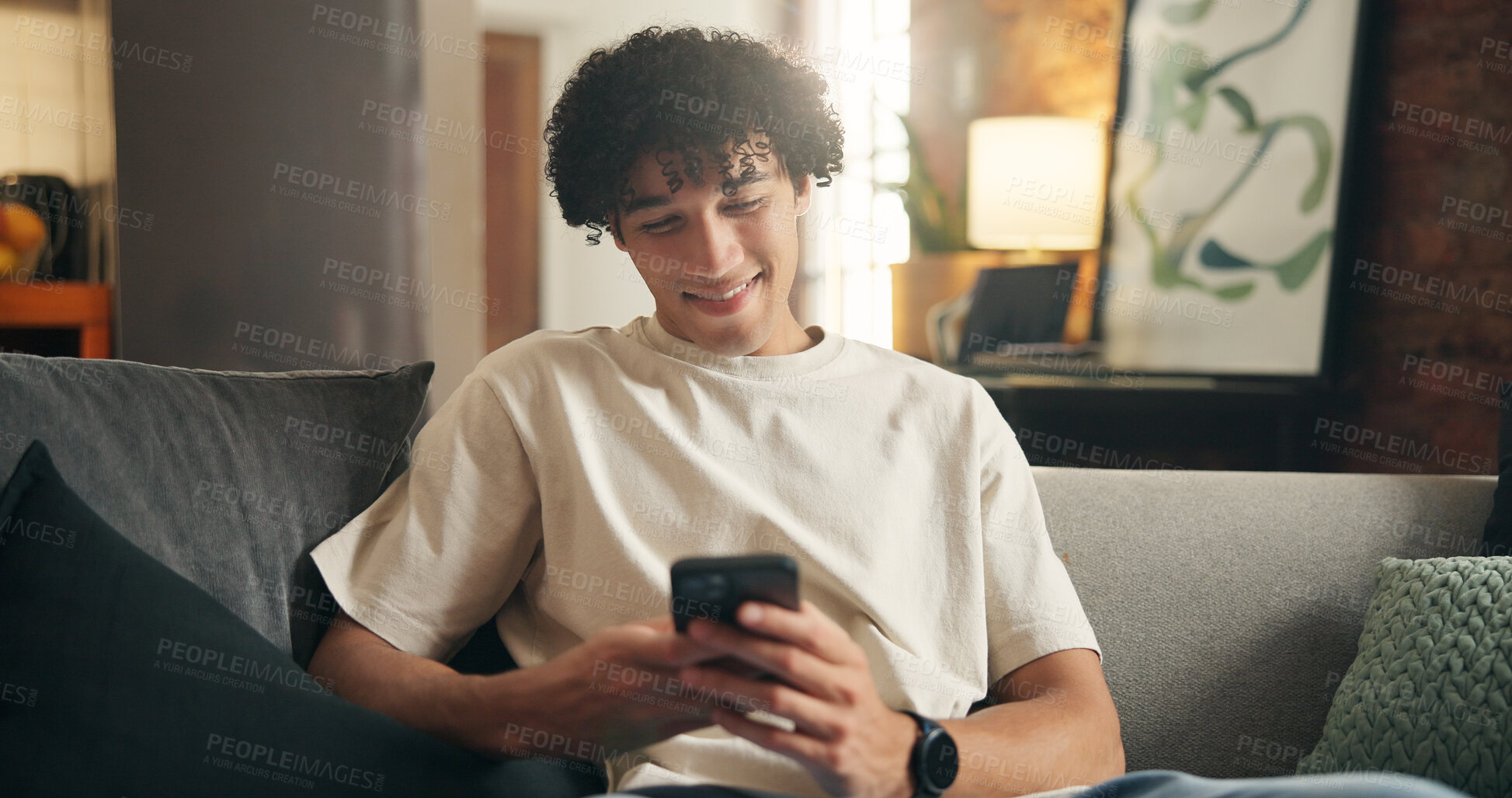 Buy stock photo Smartphone, relax and man in home, smile and typing for communication, texting and message to contact. Online reading, cellphone and person on sofa, funny meme or app for social media or website info