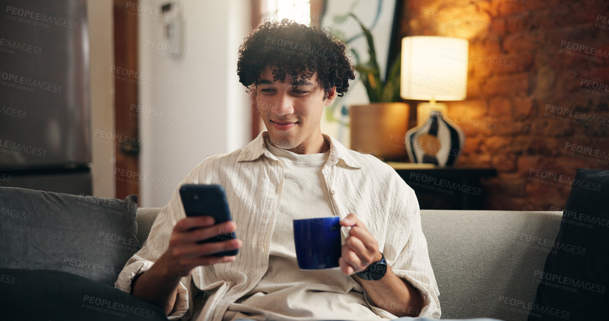 Buy stock photo Coffee, smile and man on sofa with phone for social media, online message and chat in home. Weekend, relax and person on smartphone for internet, connection and notification on mobile app with drink