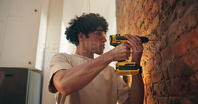 Buy stock photo Brick wall, drill and man in home, renovation and goggles for safety, improvement and remodelling lounge. DIY project, equipment and person with electric machine, maintenance and repair for upgrade