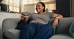 Black woman, smile and watching tv with remote in home for entertainment, streaming or video. Female person, happy and channel with choice for movie subscription, online connection or series in house