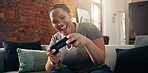 Black woman, gamer and playing with smile on sofa for esport, challenge or tournament in home. Female person, player or gaming with streaming, controller or competition on couch for contest in house