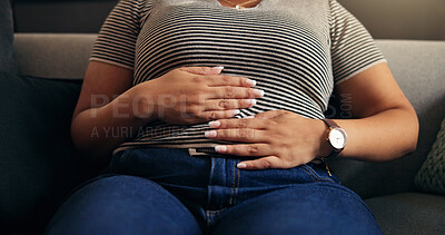 Buy stock photo Hands, stomach ache and woman in home with pain, endometriosis or menstrual cramps on sofa. Living room, sore abdomen and sick person with constipation, food poisoning and bloated with gas in house