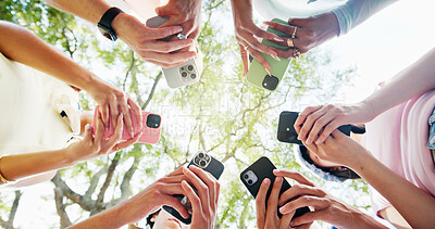 Buy stock photo Phone, circle and hands of people outdoor with networking, texting or chatting on mobile app. Technology, nature and group of students with cellphone for social media connectivity from below.