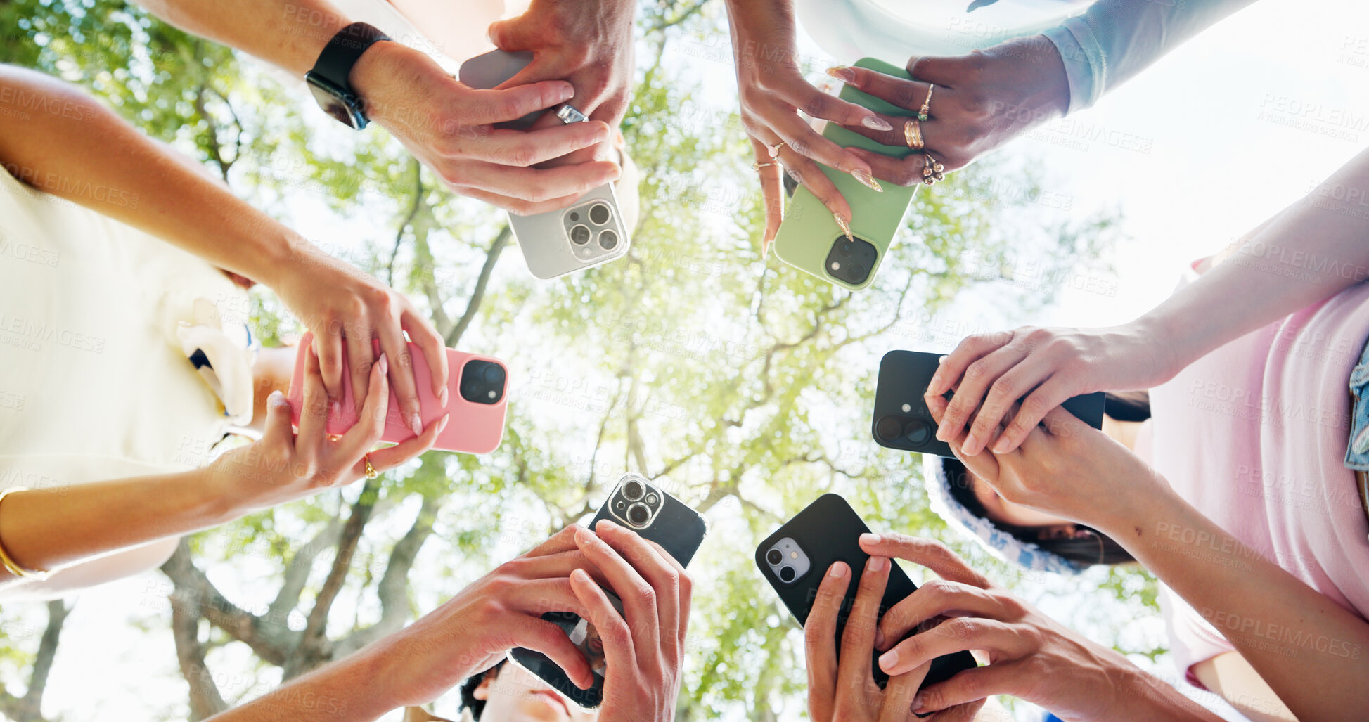 Buy stock photo Phone, circle and hands of people outdoor with networking, texting or chatting on mobile app. Technology, nature and group of students with cellphone for social media connectivity from below.