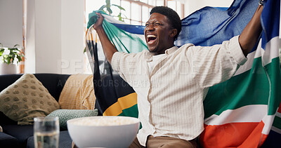 Buy stock photo Black man, South African flag and celebration in home, soccer and cheering for champion. Fan, shouting and happy person in lounge, football and excited for score lead, sports tournament or supporter