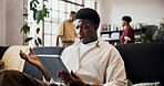 Man, tablet and stress with shock on sofa for streaming sport, goal or soccer match in home. Person, surprise and confused on application, tech or football game results on web at reunion with friends