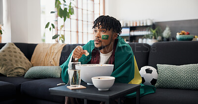 Buy stock photo Man, sports and popcorn on sofa with Brazil flag, watching tv or support national team for football. Black person, eating snack and broadcast in home with soccer world cup, tournament or live stream.