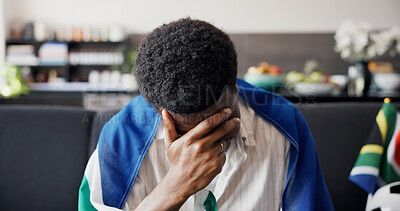 Buy stock photo Man, stress and South Africa flag for soccer on couch with disappointment, sad or loss for team in home. African person, heartbreak and frustrated on sofa, streaming and football competition at house