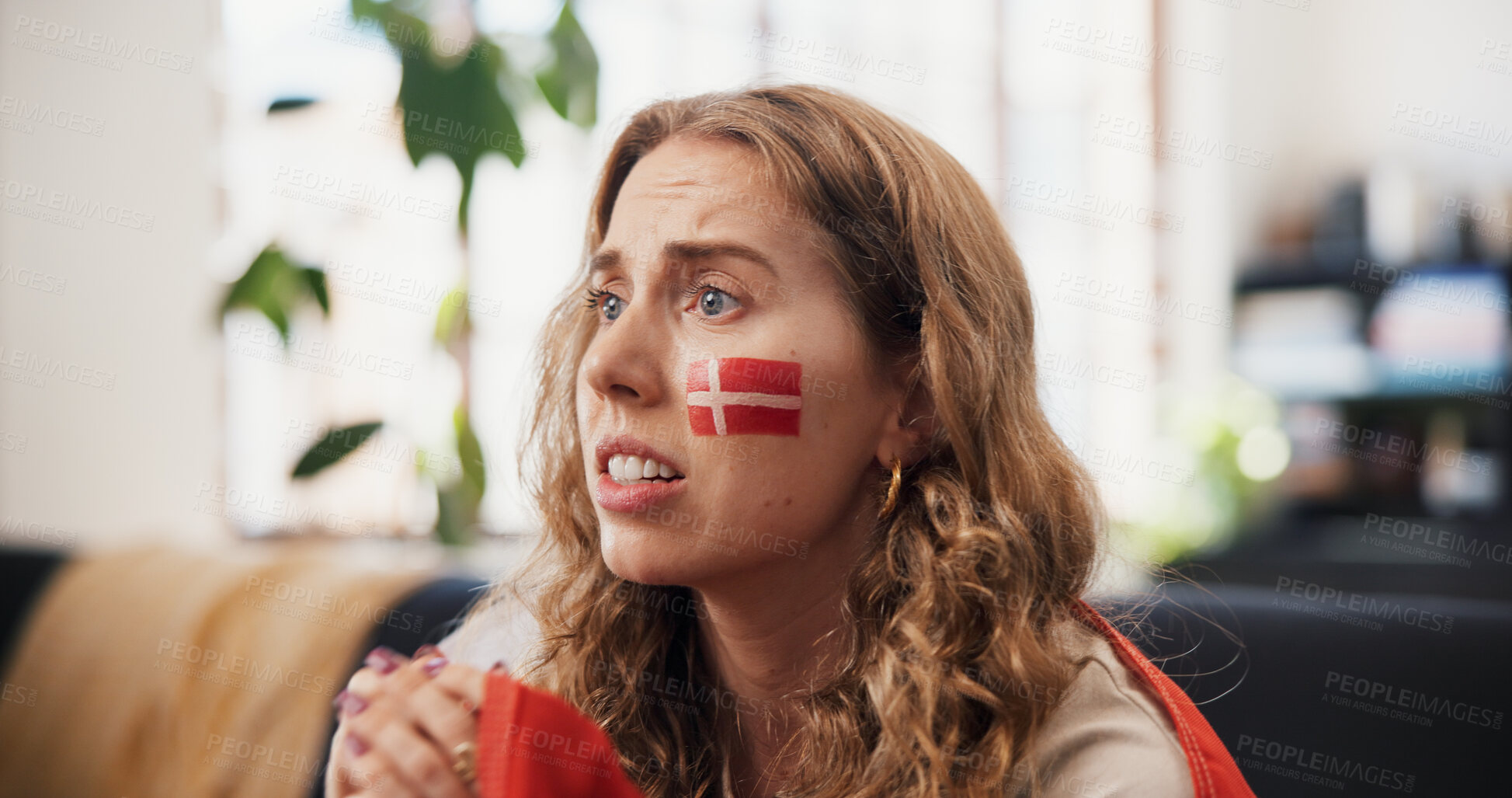 Buy stock photo Woman, sports and watching tv in home with Denmark flag, worry and suspense for football competition. Person, stress or nervous in living room with anxiety, tension or broadcast for soccer world cup.