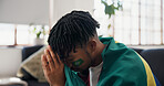 Man, sports and watching tv on sofa with Brazil flag, sad and disappointed for football match loss. Black person, stress and frustrated in home with broadcast, fail or upset for soccer world cup game