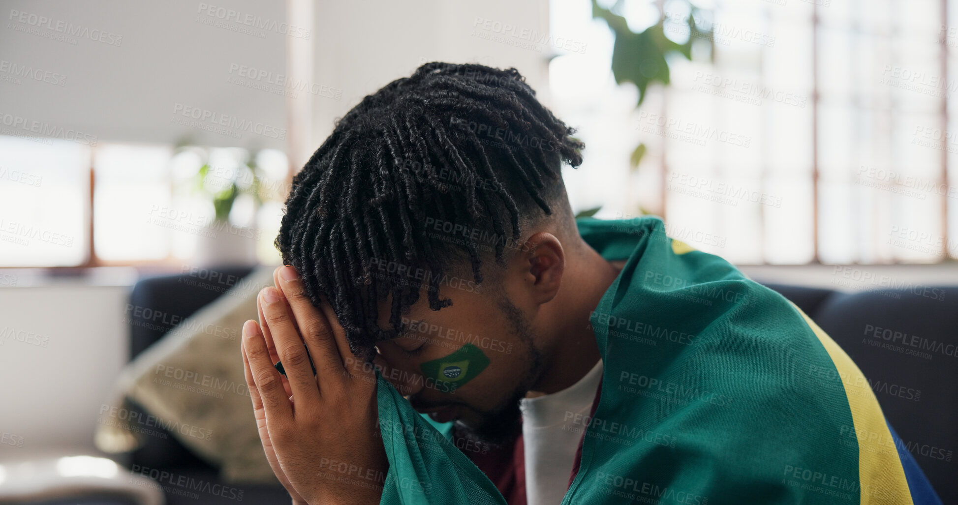 Buy stock photo Man, sports and watching tv on sofa with Brazil flag, sad and disappointed for football match loss. Black person, stress and frustrated in home with broadcast, fail or upset for soccer world cup game