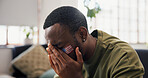 Sad man, american and sport with bad news in home for loss, defeat or soccer match on sofa. Frustrated, male person or football fan with emotion for tournament failure, score or live game in house