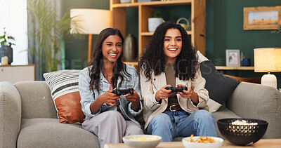 Buy stock photo Happy women, video games and playing with food on sofa for entertainment or online match in home. Female people, friends or smile with controller or snacks for console gaming or fun bonding in house