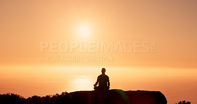 Buy stock photo Man, silhouette and meditation with sunset on mountain for spiritual wellness or healing. Calm, male person or lotus pose with sunshine on rock or cliff for zen, inner peace or mental health on space