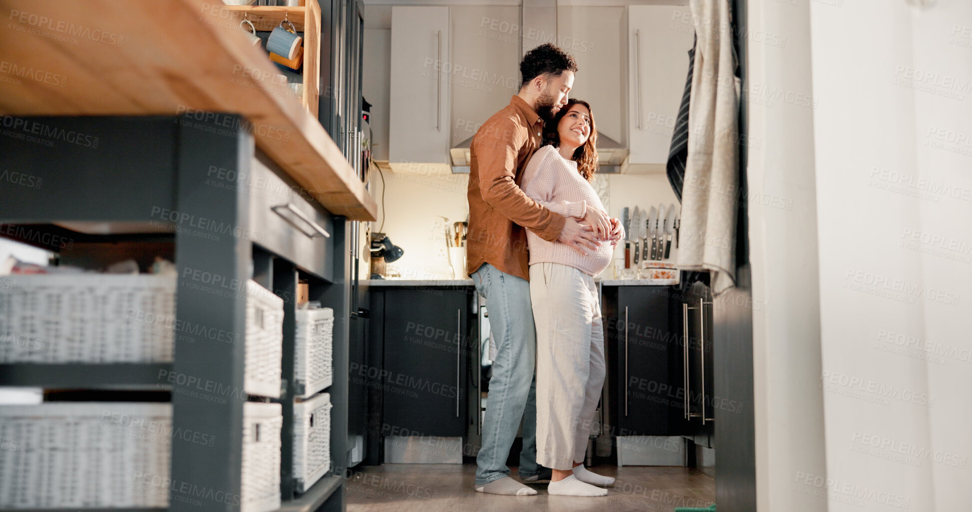Buy stock photo Hug, couple or pregnant woman with smile in kitchen of home, connection or low angle for family growth. Love, embrace or happy people with tummy touch for bonding, maternity support or future parents