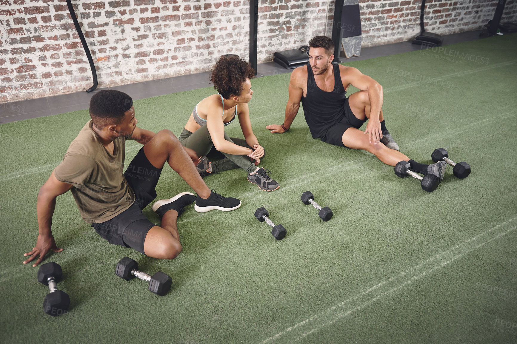 Buy stock photo Fitness, dumbbells and group of people in gym for conversation on workout, training or wellness. Equipment, friends and athletes with weights for exercise, active or challenge in sports center.