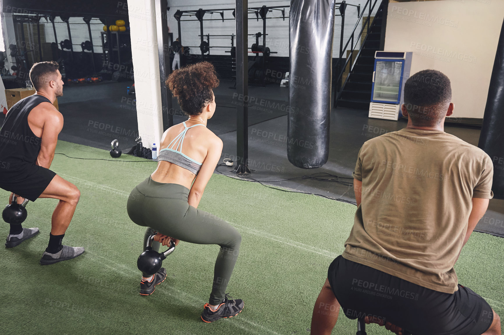 Buy stock photo Group, squat and exercise with kettlebell in gym, personal trainer or training together for strength. Health club, back and people with weights for workout, fitness and balance for muscle development