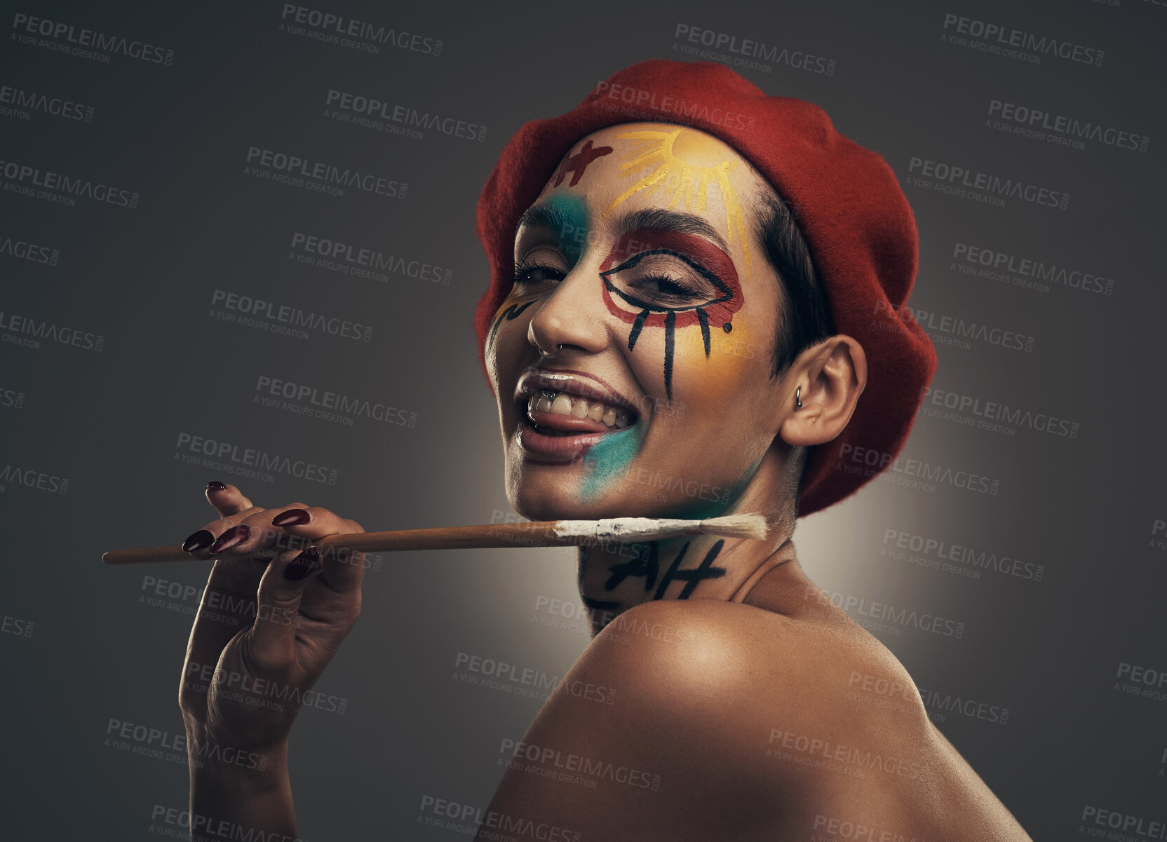 Buy stock photo Portrait, paintbrush and happy woman in studio with face paint, beret and passion for creative expression. Person, art tools and vibrant makeup with unique aesthetic, hat or smile on gray background.