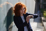 Beautiful business woman using smart watch in city red head female with wearable mobile technology