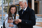 Business people using smartphones in city young personal assistant woman showing mobile phone to senior businessman 