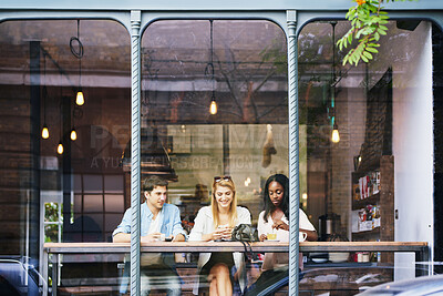 Buy stock photo Mobile, friends and people at cafe window, relax and check social media post, bonding or hangout. Coffee shop, smile or group with phone for text, drink or customers chill together in city on weekend